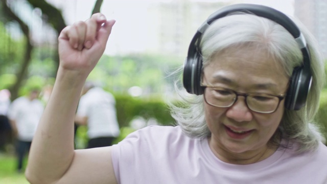 老年妇女听音乐跳舞的慢动作视频视频下载