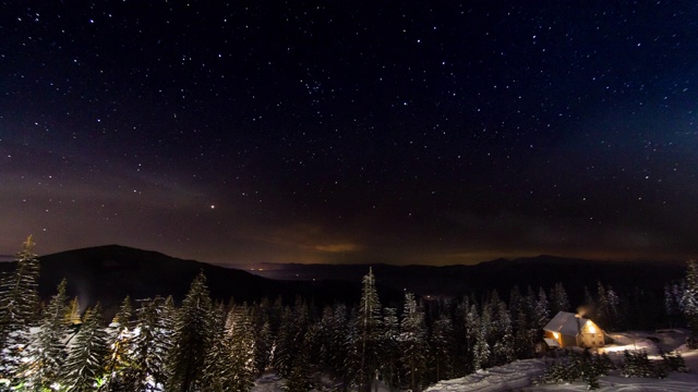 星星延时:冬天山上小房子上方移动的星星。乌克兰,喀尔巴阡山脉的视频素材