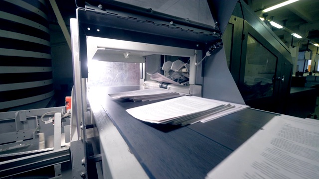 印刷传送带移动成堆的纸，靠近。视频素材