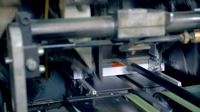 近距离看，印刷设备在传送带上与书籍一起工作。视频素材