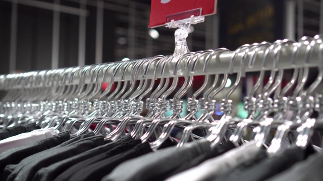 在百货公司，购物中心和服装概念的时尚服装店挂衣架和衣架上的扶手4k镜头的场景视频素材