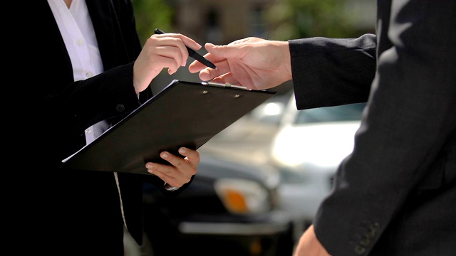 女性签署保险文件，并与汽车代理人握手视频下载