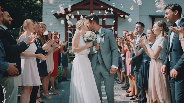 宾客将花瓣抛向离开教堂的新婚夫妇视频下载