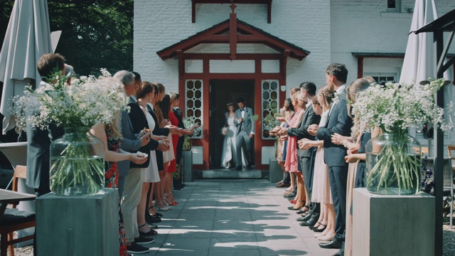 宾客们在教堂外向新婚夫妇投掷花瓣视频下载