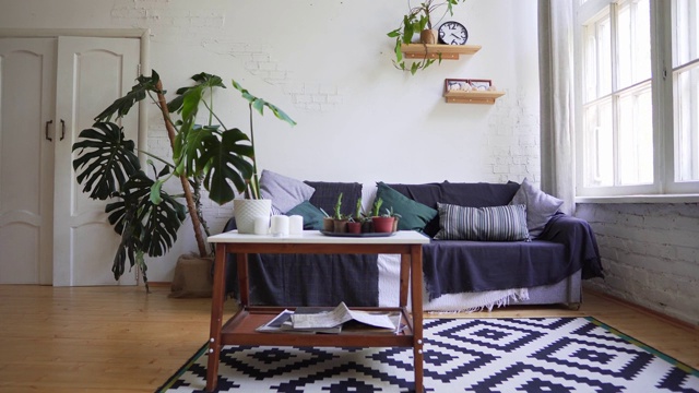 一张漂亮的地毯，一张放着杂志的小桌子，一张靠墙的舒适沙发。阁楼公寓视频素材