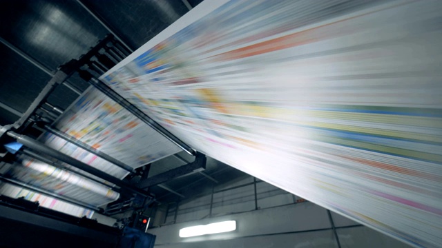 印刷报纸在滚动传送带上，印刷办公设备。视频素材