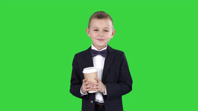 一个男孩穿着正装拿着外卖咖啡走在绿屏上视频素材