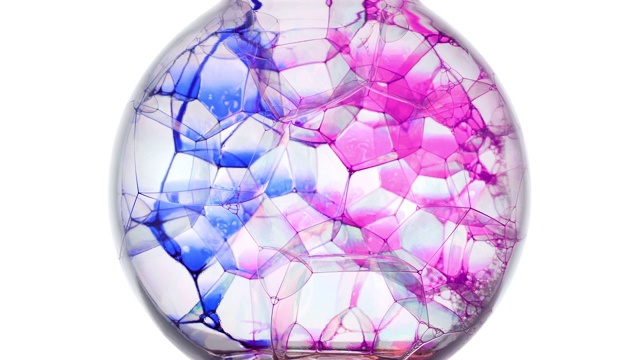慢镜头和特写，蓝色和粉红色的墨水在一个球里的肥皂泡上扩散开来视频素材