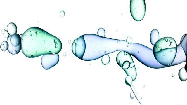 近距离和缓慢的运动倒蓝色和绿色的油从右边和创造一排泡沫水下，而反弹在白色的背景视频素材
