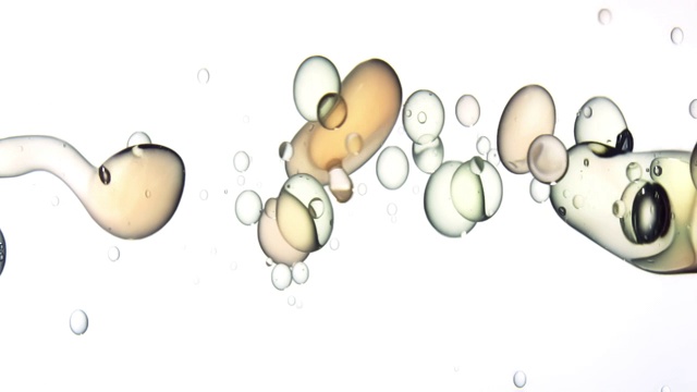 近距离和缓慢的运动倒浅色油从右和创造一排泡沫在水中，而反弹在白色背景视频下载