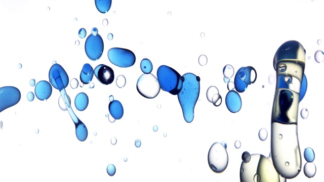 近距离和缓慢的运动倒蓝色的油从右边和创造一排泡沫水下，而反弹在白色的背景视频素材