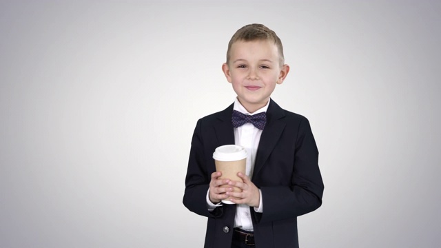 男孩走在一个带走咖啡在正式的衣服在梯度背景视频素材