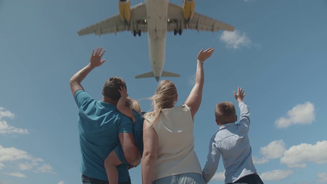 一个年轻的家庭迎接飞机，在上面飞行视频下载