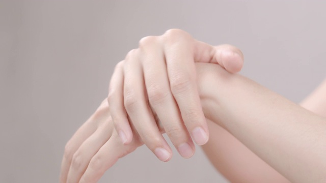 4k分辨率亚洲成年妇女使用手涂抹保湿化妆品霜在她的手。身体保健的概念。视频购买