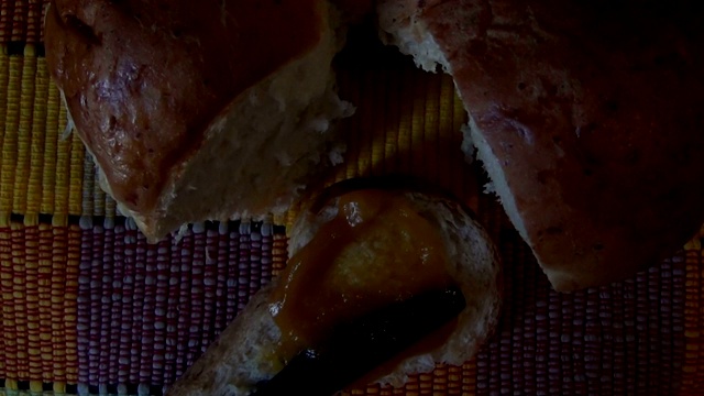 俯视图:在一片自制的面包和咖啡上涂上杏子果酱。视频下载