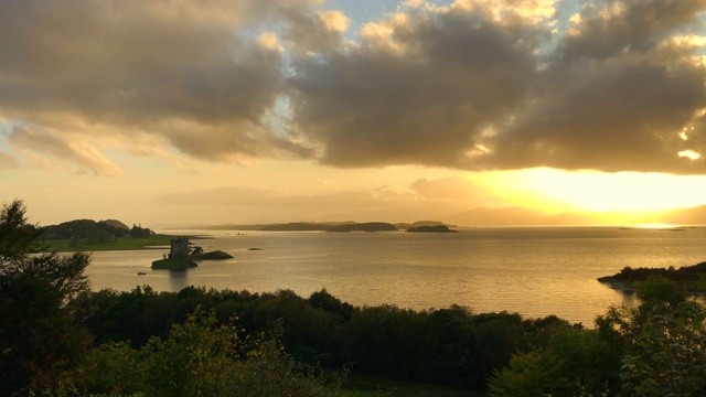 随着时间的推移，在苏格兰海的中央岛上的跟踪者城堡与金色的光。视频下载