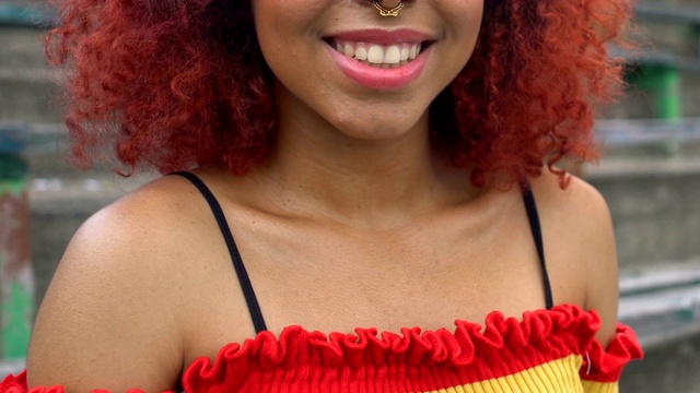 快乐的美国黑人红头发年轻女性穿鼻环对着镜头微笑视频下载