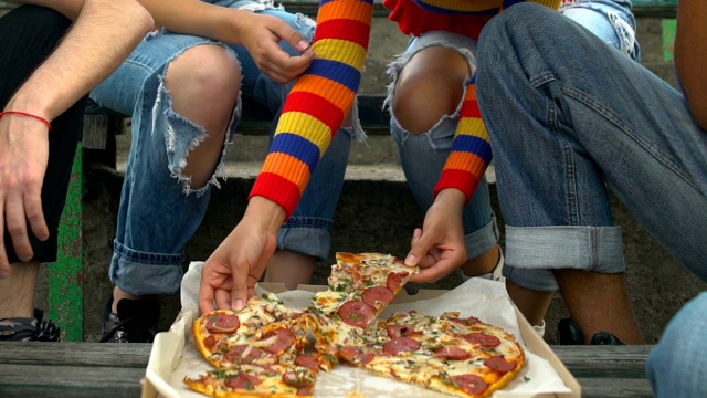 多种族青少年朋友吃美味的披萨片户外小吃，快餐餐视频下载
