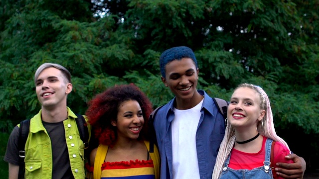 兴奋的多种族学生情侣在公园散步微笑，友谊视频下载