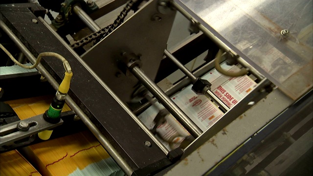 一台自动机器对微波爆米花的袋子进行分类。视频素材