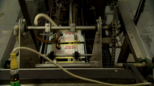 一台自动机器为微波爆米花袋封口。视频素材
