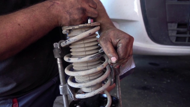 汽车修理工，用螺丝刀拧紧发动机部件的螺丝视频素材