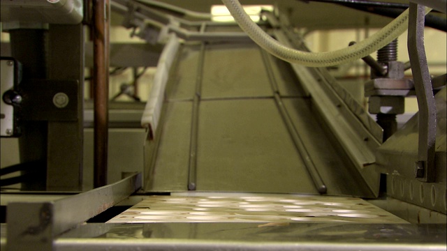 在工厂里，糖果模具沿着滑槽滑到传送带上。视频素材