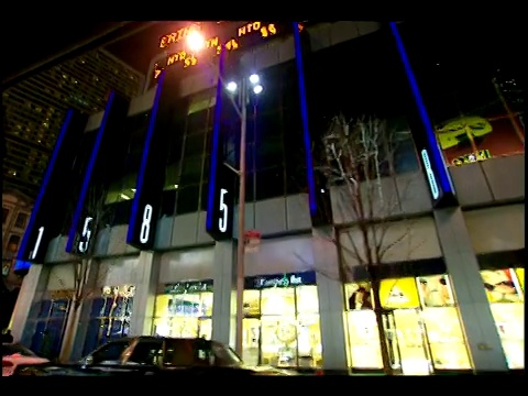 在纽约市百老汇街的1500街区，霓虹灯和招牌照亮了建筑的正面。视频下载