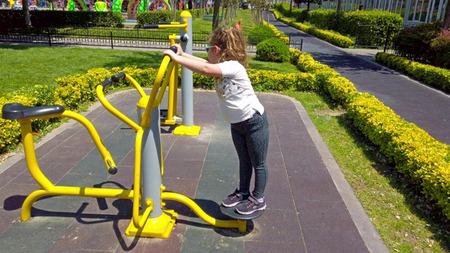 小女孩在公园里做扭转运动视频下载