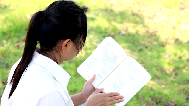一位妇女正在公园里看书。视频素材