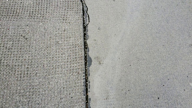 城市街道沥青裂缝-俯视图行走。混凝土背景纹理循环视频下载