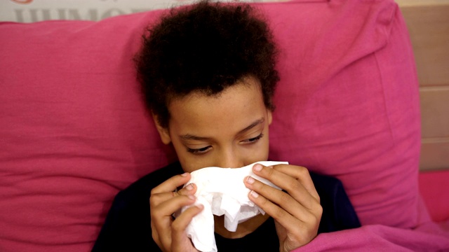 流感季节。生病的女孩躺在床上，盖着一条毯子，高烧和流感。视频素材