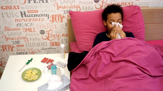 生病的女孩躺在床上，盖着一条毯子，高烧和流感。视频素材