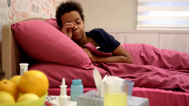 生病的小女孩得了流感，躺在家里测量体温视频素材