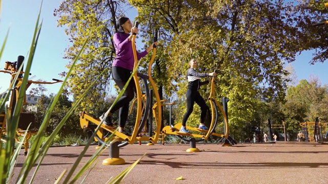运动女孩在操场上骑着自行车锻炼身体视频下载