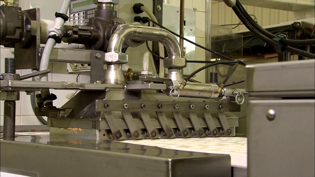 一台机器用花生酱填充糖果模具。视频素材