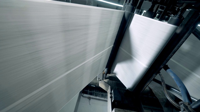 印刷厂的传送带上卷着白色的纸。视频素材