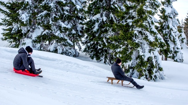 两个人滑着雪橇下山视频下载