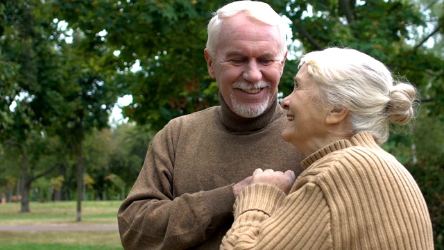 成年夫妇享受生活拥抱在秋天的公园，爱和奉献，慢动作视频素材