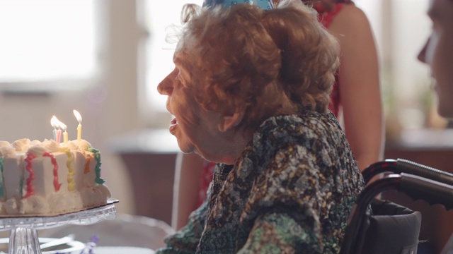 在和家人一起庆祝她的100岁生日时，曾祖母吹灭了生日蛋糕上的蜡烛视频下载