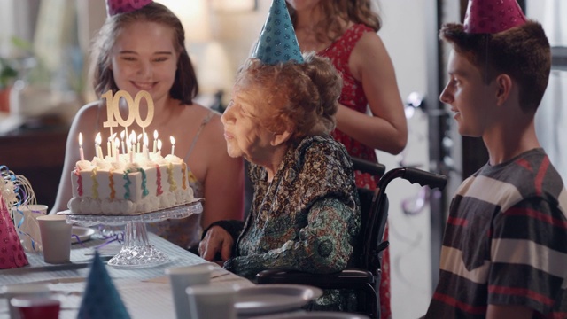 曾祖母和曾孙在她百岁生日宴会上吹熄了生日蛋糕上的蜡烛视频下载