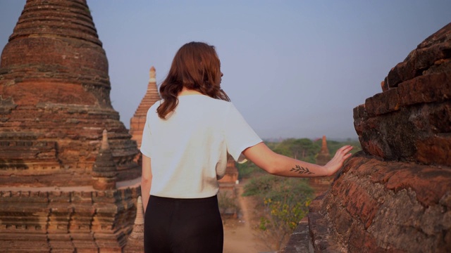 一名女子走在宝塔上，观赏蒲干遗址的风景视频下载