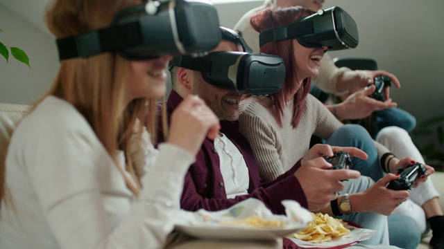 一群朋友在客厅里使用虚拟现实模拟器眼镜。慢动作拍摄视频素材