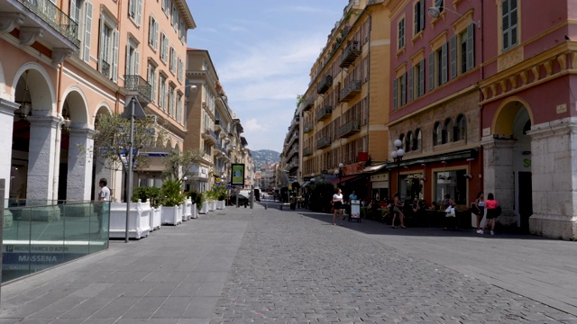 4k在法国尼斯的主街Jean大街上看Médecin。展示了酒吧、商店和餐馆，人们在一个明媚温暖的夏日里四处走动。视频下载