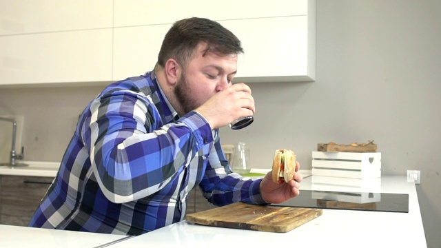 胖子吃肥肉汉堡，吃快餐，喝有害的柠檬水，超重，慢动作视频素材
