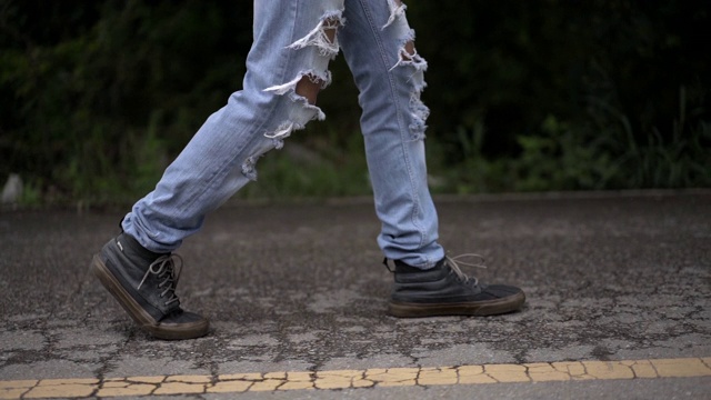 低截面的亚洲人在时尚直瘦裤损坏洞牛仔牛仔裤破洞瘦裤走路视频下载