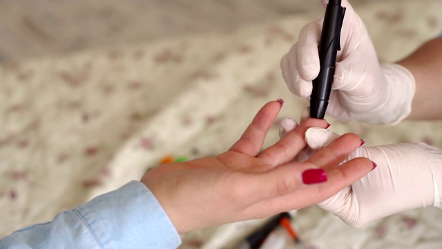 女孩用剃刀刺穿他的手指检查血液中的葡萄糖水平视频素材
