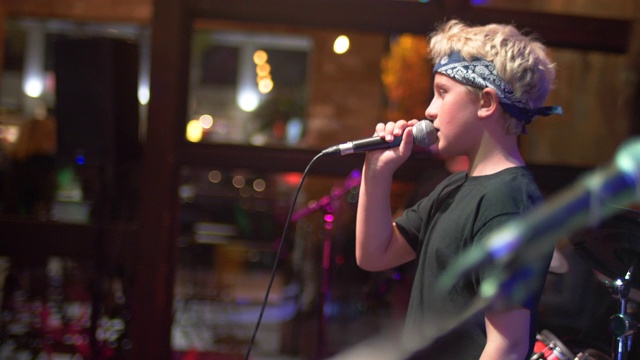 一个音乐家，歌手，摇滚明星，青少年，在一个摇滚乐队的舞台上唱歌。视频下载