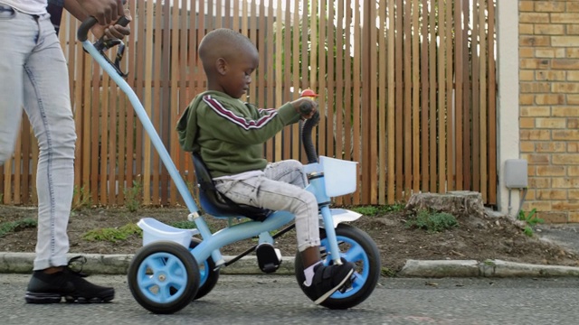 小男孩骑着三轮车在太阳耀斑外面视频下载