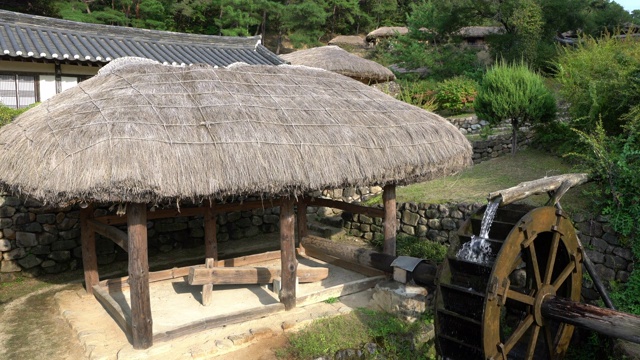韩国安东民俗村的传统茅草屋和古老的木磨视频下载